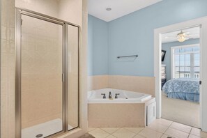 Ein Badezimmer mit Dusche, Badewanne und Fenster.