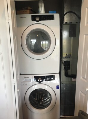 A stacked washer and dryer unit with a Samsung label, a control panel, and a 10-year warranty sticker. - Spacious 7-bedroom Beach House in fantastic Ocean Isle Beach w/ Private Pool&AC (Ocean Isle Beach)