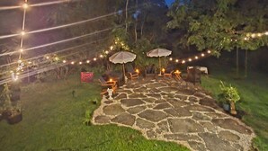 An outdoor patio area with stone flooring, outdoor seating, and string lights. - Historic 1825 Chesapeake Farm Stay  (St. Leonard)