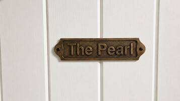 A door with a brass nameplate that reads 'The Pearl.'