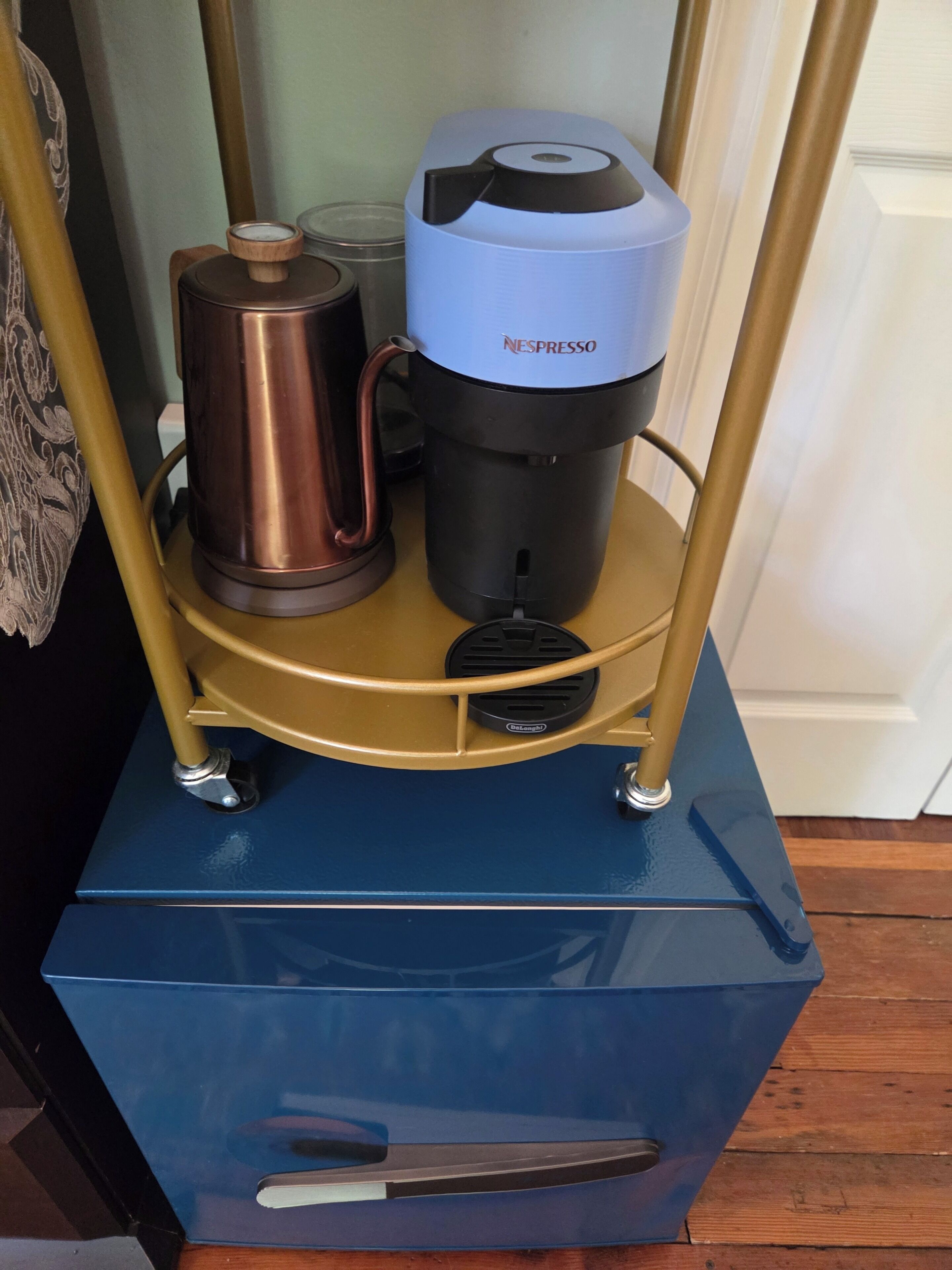 Una macchina da caffè su un carrello con un bollitore e una caffettiera.