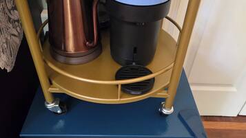 Una macchina da caffè su un carrello con un bollitore e una caffettiera.