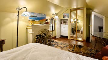 A bedroom with a bed, a dresser, a mirror, and a dog.