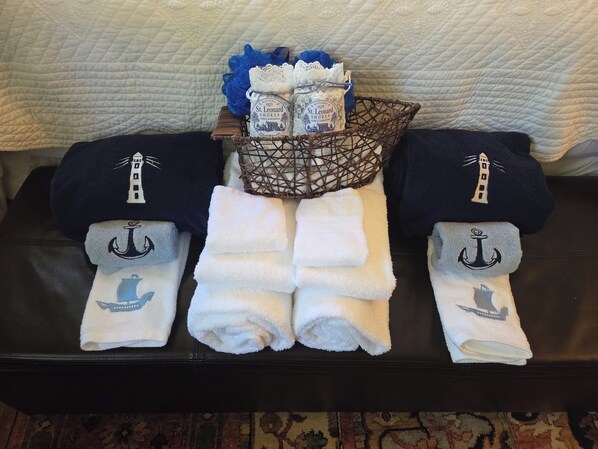 A set of towels and bottles on a leather bench. - Historic 1825 Chesapeake Farm Stay (St. Leonard)