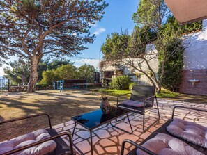 An outdoor patio with a stone floor, metal chairs, a table, and a bench. - Apartmani Zoricic 1 / HR-11028-01 by Interhome (Novi Vinodolski)
