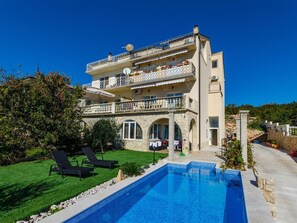 A multi-story building with a swimming pool, outdoor seating, and a stone facade. - TIJANA 2 / HR-07197-02 by Interhome (Novi Vinodolski)