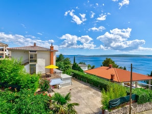 A coastal property with a patio, a view of the sea, and a clear sky. - AZUR 1 / HR-04335-01 by Interhome (Crikvenica/Dramalj)