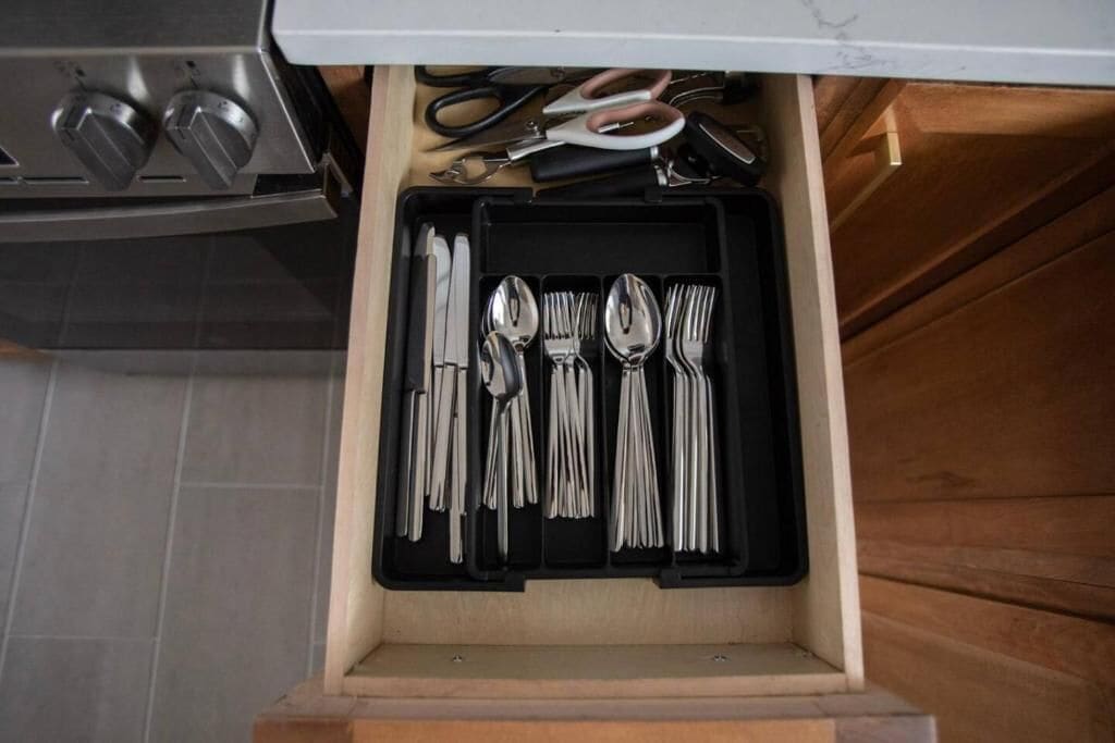 A drawer containing various utensils including forks, spoons, and knives.