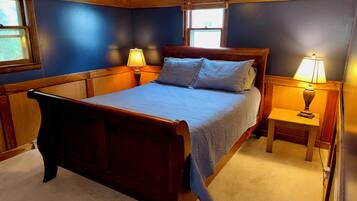 Un dormitorio con cama de madera, dos lámparas de noche y una ventana con persianas.