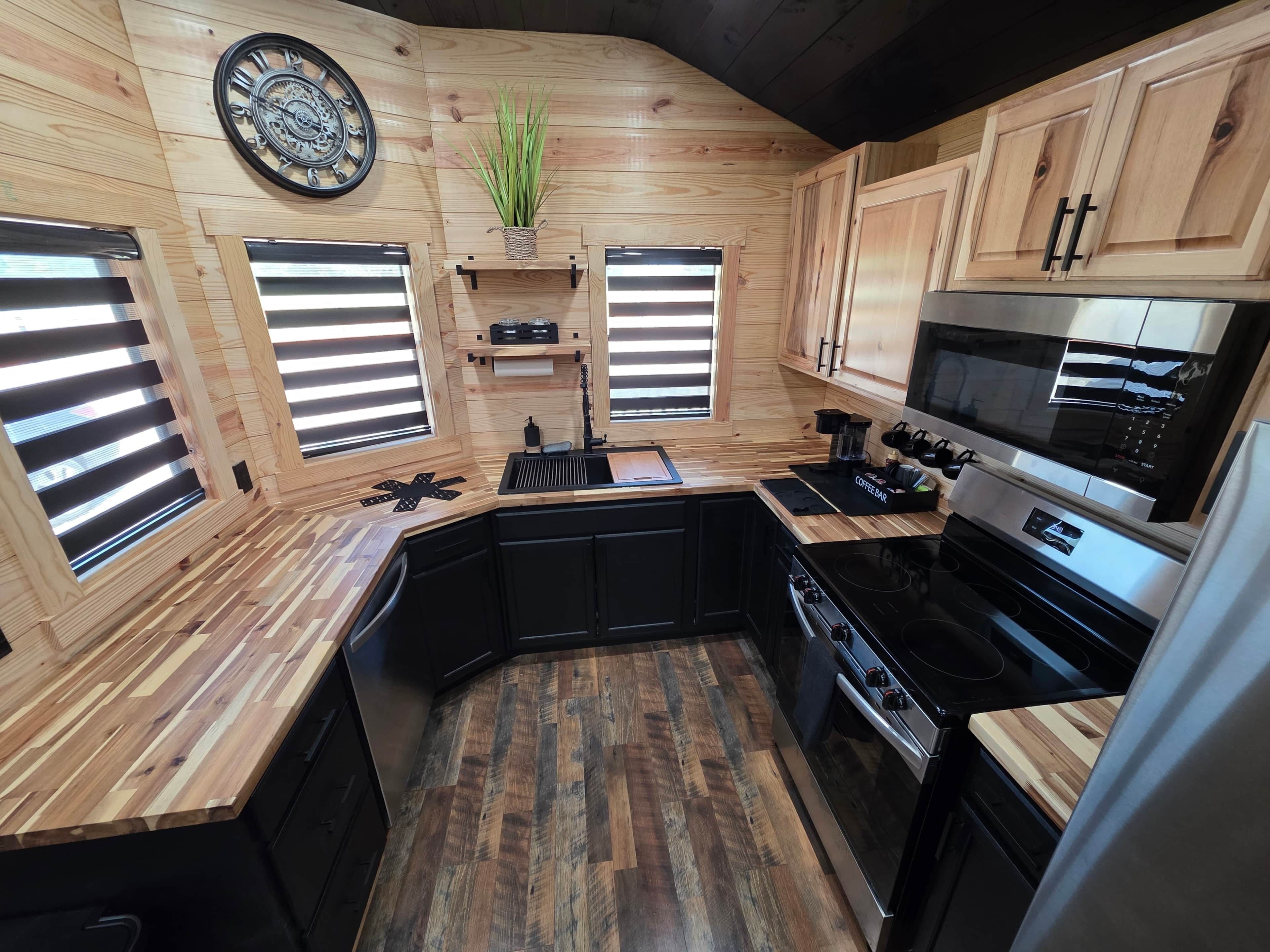 Una cocina con armarios de madera, estufa integrada y una barra para café.