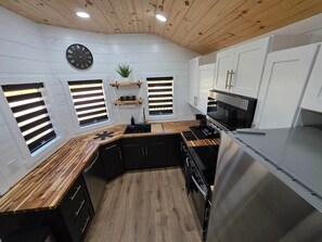 Eine moderne Küche mit Holzboden, weißen Wänden und integrierten Geräten.