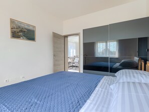 Ein Schlafzimmer mit einem Bett, einem Nachttisch, einem Spiegel und einem Bild an der Wand.