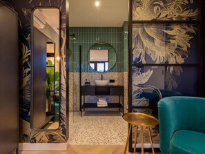 A modern bathroom with a mirror, sink, and a teal chair. - RustUit by Interhome (Koudekerke)