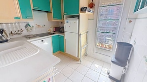 A kitchen with teal cabinets, a white refrigerator, and a tiled backsplash. - Apartment sea view - 4 guests (Cabourg)