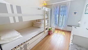 A bunk bed room with a desk, a lamp, and a window with curtains. - Apartment sea view - 4 guests (Cabourg)