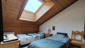 A bedroom with two beds, a desk, a chair, and a skylight. - Spacious apartment with parking - 6 guests (Crest-Voland)