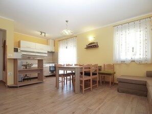 Ein gemütlicher Wohnbereich mit Küche, Essbereich und einer Couch.