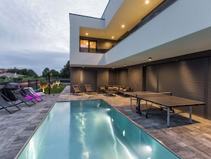 A modern outdoor pool area with a sunken seating area and a ping pong table. - House 2258 by Interhome (Pula)
