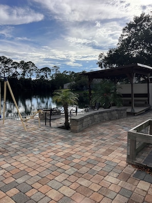 A paved patio with a view of a lake, a swing set, and a covered seating area. - Beautiful 3-bedroom townhome with AC in wonderful Jacksonville (Jacksonville)