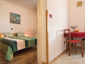 A room with a bed, a chair, a table with fruit, and a clock on the wall. - Apartment 354 by Interhome (Fažana)