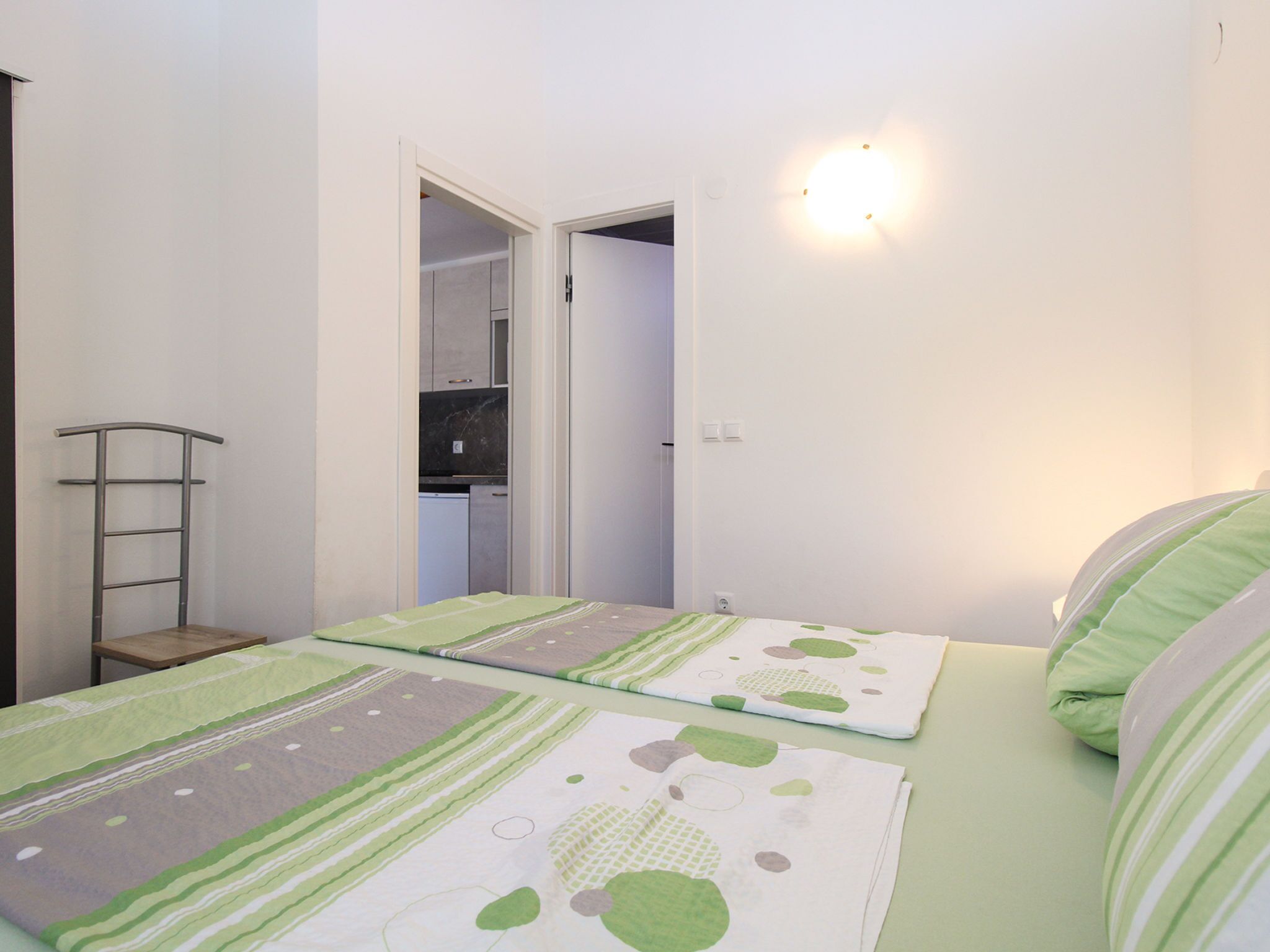 A bedroom with two beds, a wardrobe, and a mirror.