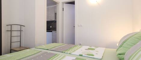 A bedroom with two beds, a wardrobe, and a mirror.