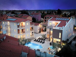 Un immeuble résidentiel doté de nombreux balcons, d’une piscine et d’une cour bien éclairée.