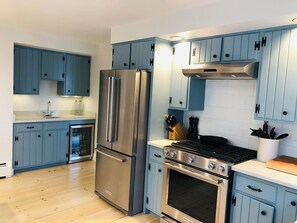 Eine moderne Küche mit blauen Schränken, Edelstahlgeräten und einem eingebauten Backofen.