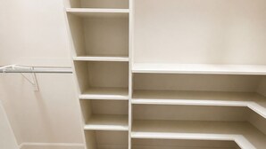 Un vestidor con amplios estantes y una barra metálica para colgar prendas.