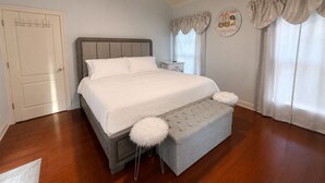 A bedroom with a bed, a nightstand, a chair, and a ceiling fan. - Welcome to Magnolia Pearls, a peaceful retreat for comfort and relaxation. (Prairieville)