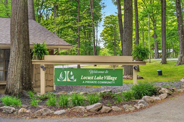 Ein Schild, das herzlich in Locust Lake Village willkommen heißt, eine private Siedlung.