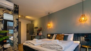 Ein modernes Hotelzimmer mit einem großen Bett, einem Schreibtisch und einem Spiegel.