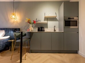 A modern kitchen with a built-in oven, a coffee machine, and a small bar area. - Studio ZeeRust by Interhome (Koudekerke)