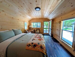 A wooden cabin interior with a bed, desk, and large windows. - NEW Donnell Pond Cabin, free kayaks, hiking, fishing (Franklin)