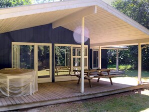 Uma área externa coberta com uma mesa de piquenique e um espaço de estar coberto.