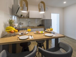 Una cocina moderna con una isla central, equipada con un fregadero, un refrigerador e iluminación colgante.