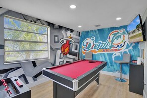 Ein Billardtisch mit roter Spielbahn, ein Schussstab und ein Spielball.