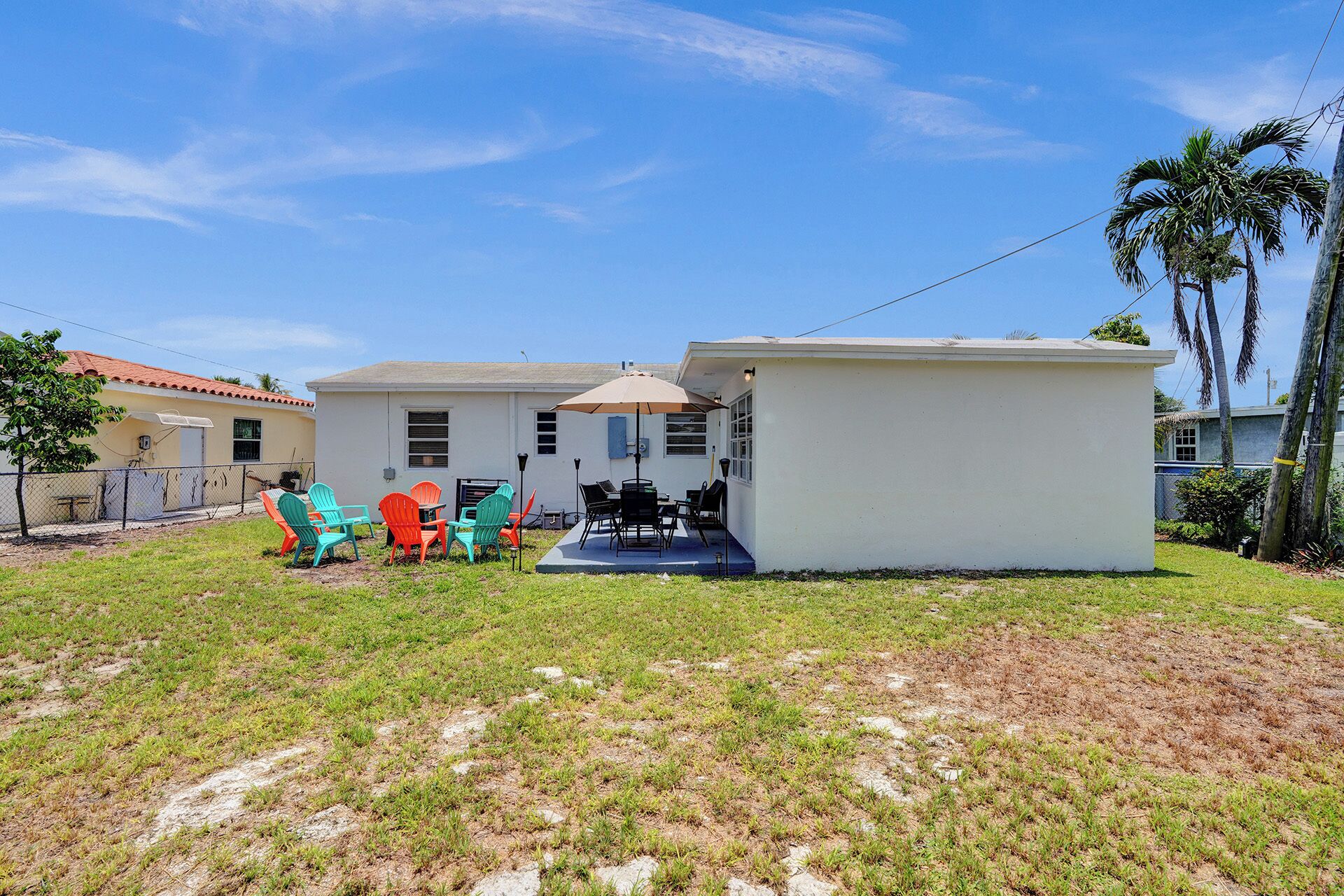 A house with a patio, outdoor furniture, and a small building.