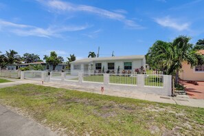 A residential property with a white fence, a 'No Parking' sign, and a clear blue sky. - MiamiMuralHouse:4BRw/Themes, Gameroom, Backyard (Miami)