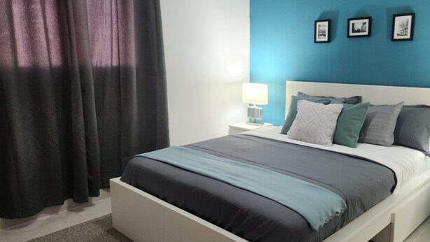 Een moderne slaapkamer met een bed, twee nachtkastjes en een nachtkast.