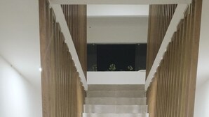 Een trap met een modern ontwerp, met een houten leuning en een lichtgekleurde vloer.