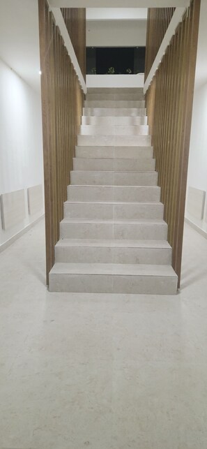 A staircase with a modern design, featuring a wooden handrail and a light-colored floor. - Amazing Suites 2-bedroom apartment with AC in Punta Cana (Punta Cana)