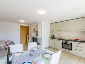 A modern apartment with a dining area, kitchen, and living space. - Leng 1 / HR-10352-01 by Interhome (Crikvenica/Dramalj)