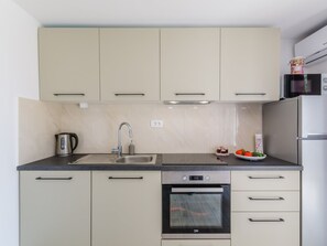 A modern kitchen with a built-in oven, stainless steel sink, and a microwave. - Leng 1 / HR-10352-01 by Interhome (Crikvenica/Dramalj)