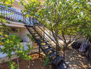 A residential area with a staircase leading to a balcony, surrounded by trees and plants. - Azur 3 / HR-04335-03 by Interhome (Crikvenica/Dramalj)