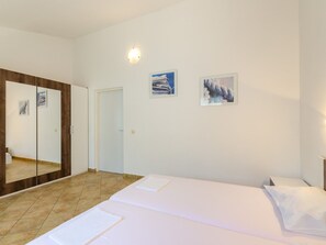 A bedroom with a bed, a wardrobe, a mirror, and two wall-mounted pictures. - LANA 3 / HR-02384-03 by Interhome (Crikvenica)