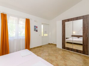 Ein Hotelzimmer mit Bett, Kleiderschrank, einer Badezimmertür und Blick nach außen.