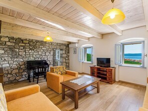 A cozy living room with a stone wall, wooden ceiling, a piano, a TV, and a view of the sea. - SARAR KOTOR CH / HR-10358-02 by Interhome (Crikvenica)
