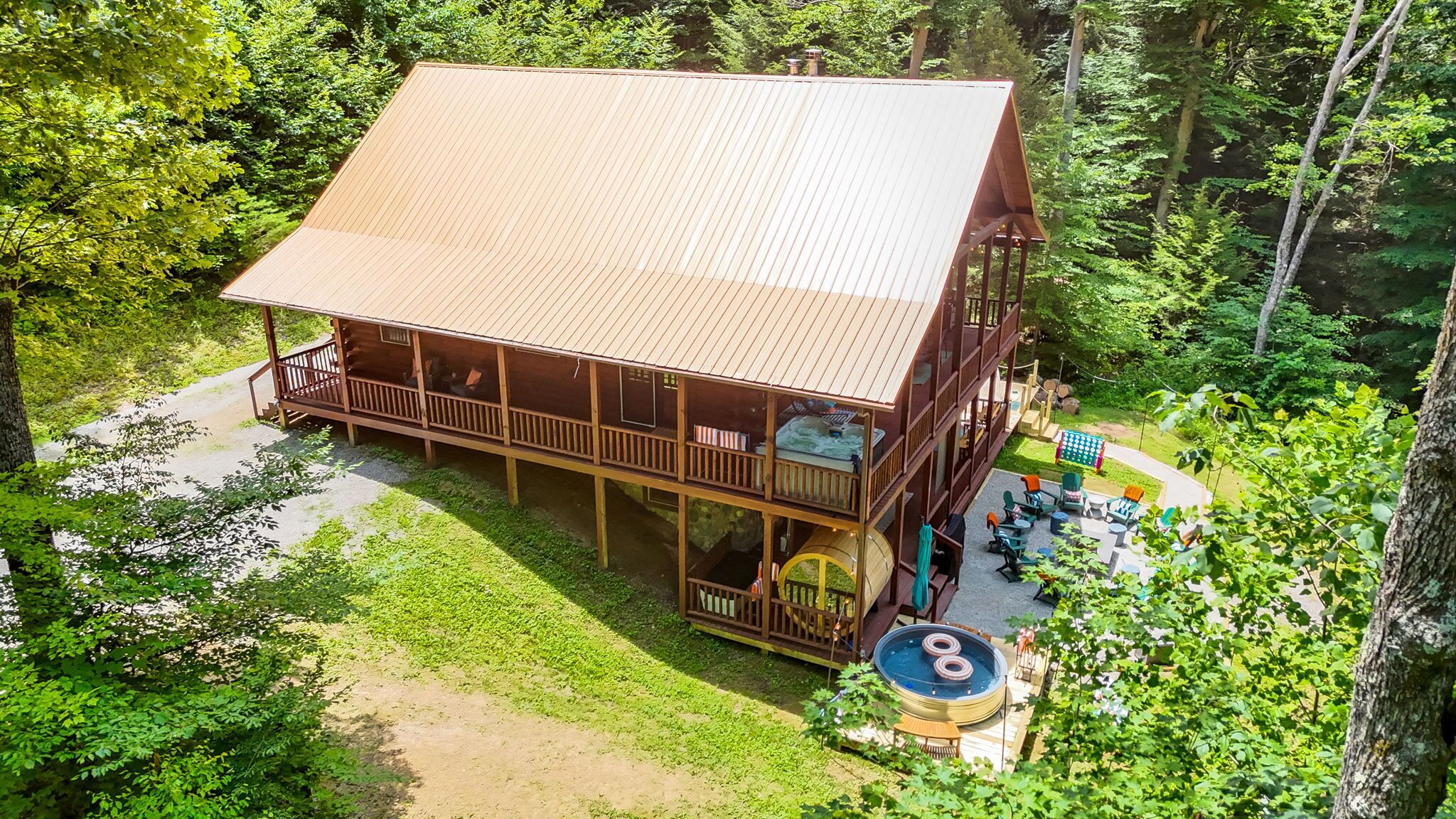 A two-story log cabin with a deck and outdoor seating area.