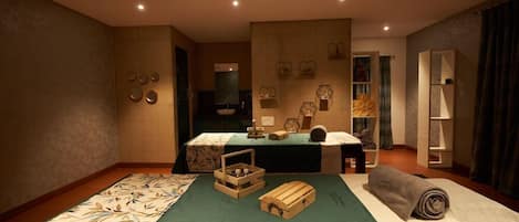 Habitación de hotel con cama, escritorio, espejo y estante con objetos decorativos.